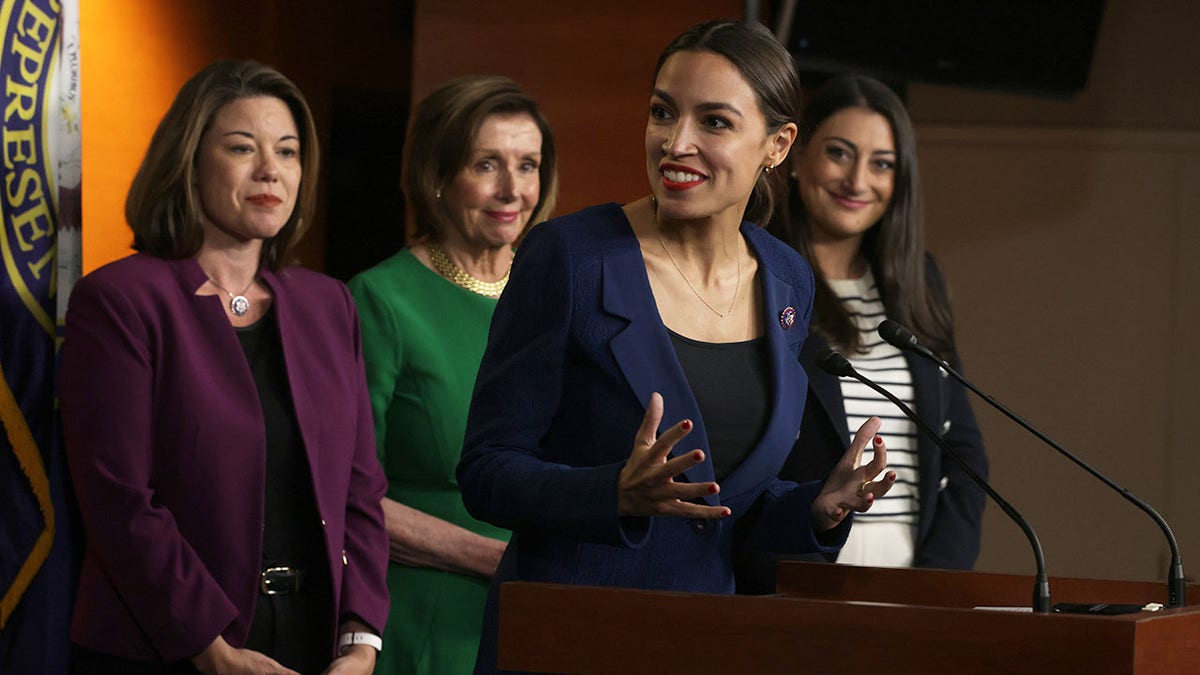 Ocasio-Cortez next to Nancy Pelosi, fellow democrats