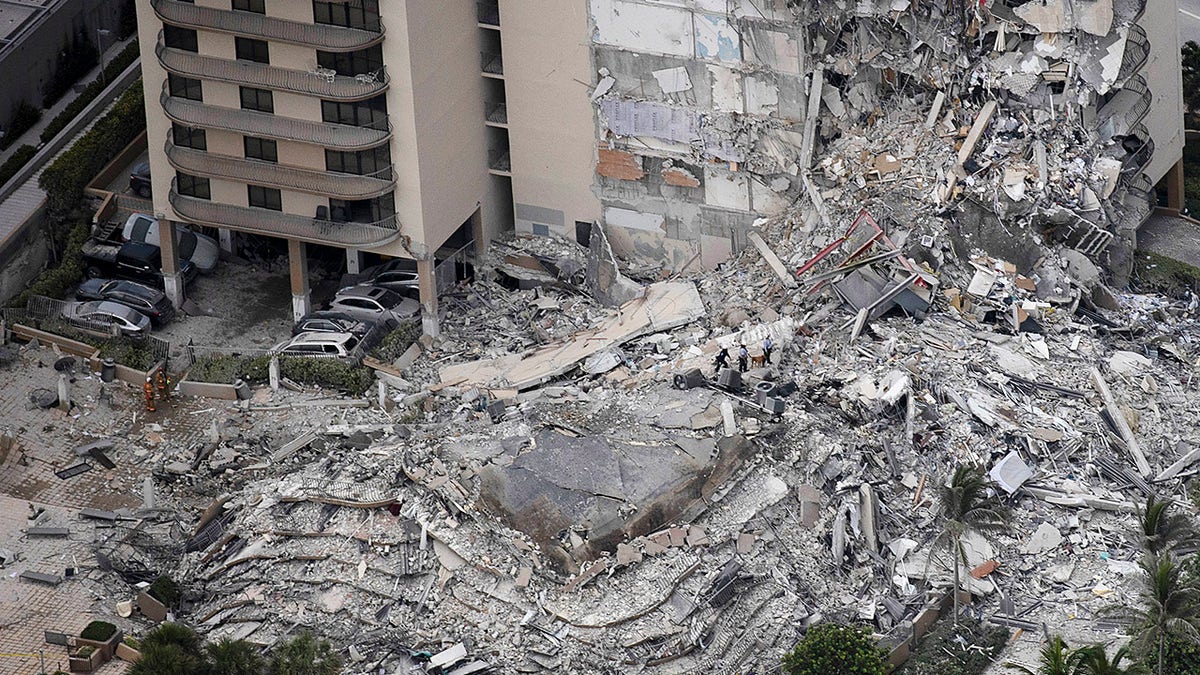 Search-and-rescue personnel with a K-9 unit work in the rubble of a 12-story residential tower that partially collapsed on June 24, 2021, in Surfside, Fla. It is unknown how many people were injured as search-and-rescue effort continues with rescue crews from across Miami-Dade and Broward counties.
