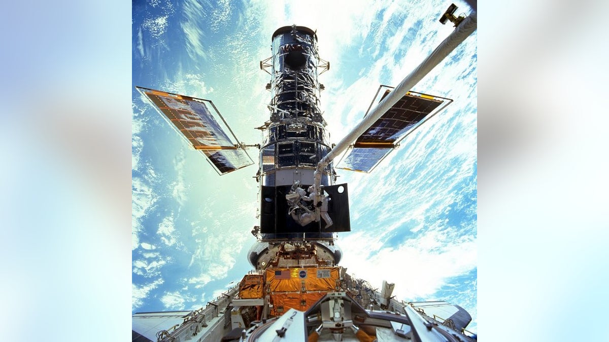 Astronauts Steven L. Smith and John M. Grunsfeld during an extravehicular activity (EVA) during the December 1999 Hubble servicing mission of STS-103, flown by Discovery. (Associated Press)