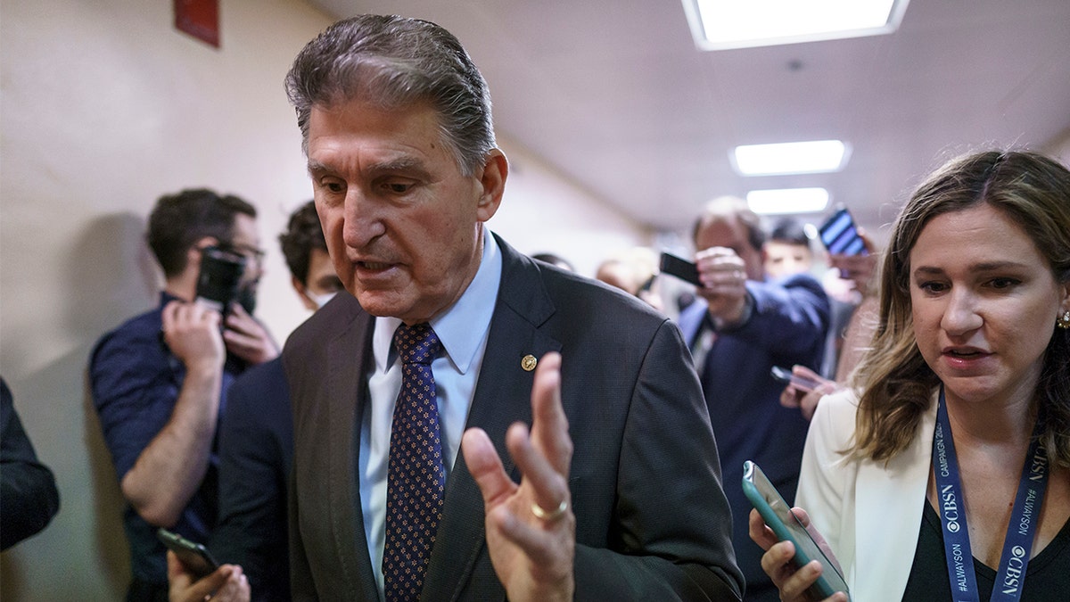 Sen. Joe Manchin, D-W.Va., a crucial 50th vote for Democrats on President Biden's proposals, walks with reporters as senators go to the chamber for votes ahead of the approaching Memorial Day recess, at the Capitol in Washington, Thursday, May 27, 2021. (AP Photo/J. Scott Applewhite)