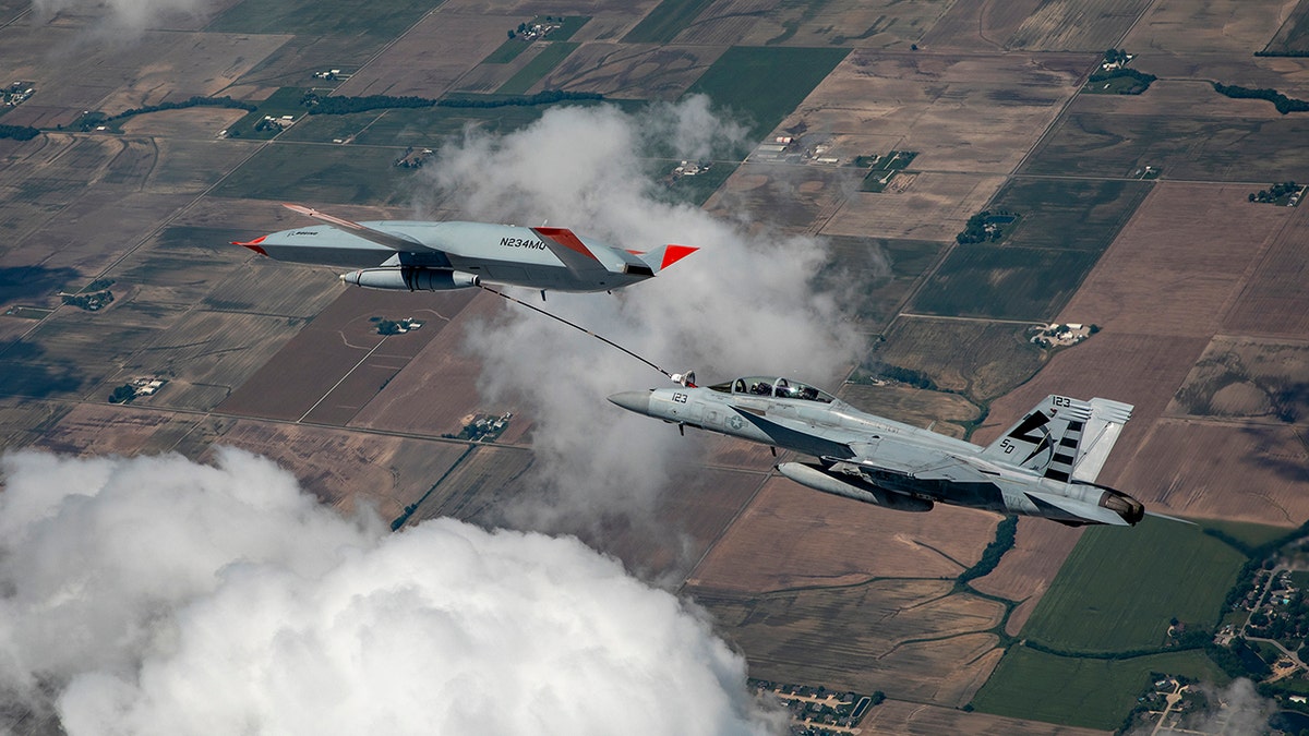 The Boeing MQ-25 T1 test asset transfers fuel to a U.S. Navy F/A-18 Super Hornet on June 4, marking the first time in history that an unmanned aircraft has refueled another aircraft. The MQ-25 Stingray will assume the carrier-based tanking role currently performed by F/A-18s, allowing for better use of the combat strike fighters and helping extend the range of the carrier air wing. (Photo by Kevin Flynn)