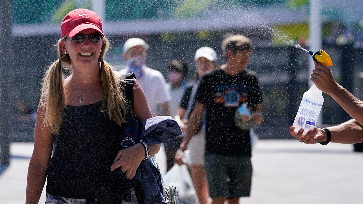 Fans gets sprayed with water after events were postponed due to high heat at the U.S. Olympic Track and Field Trials Sunday, June 27, 2021, in Eugene, Ore. (AP Photo/Ashley Landis)