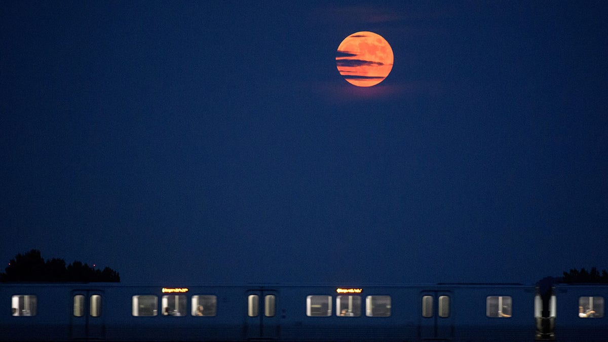 The moon rises as a Metrorail car crosses the Potomac river in Washington, D.C., on July 16, 2019. 