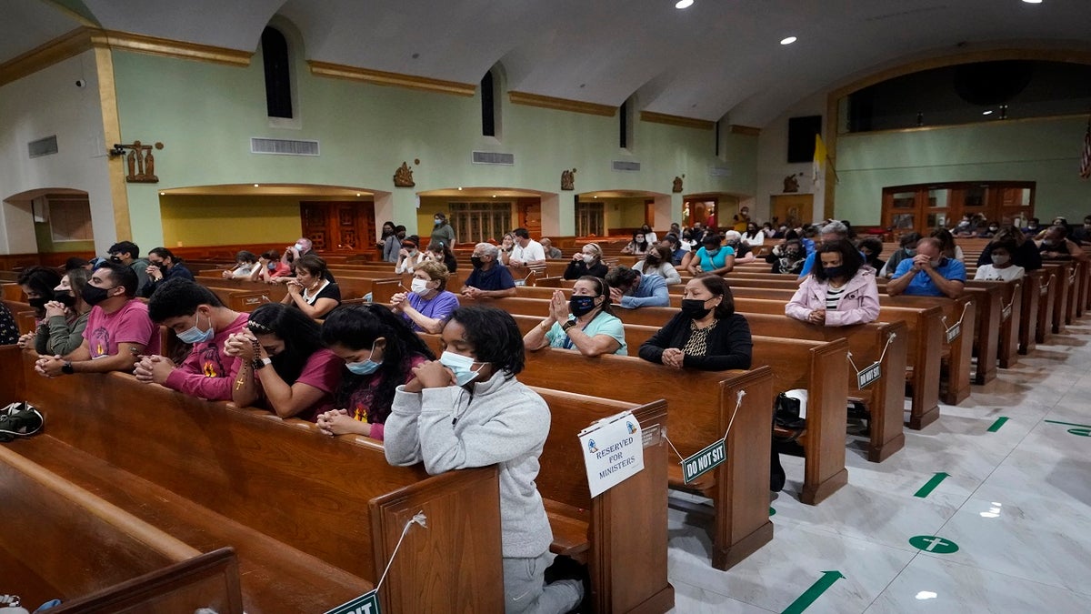 People pray late Saturday during a prayer vigil for the victims and families of the Champlain Towers collapsed building, at the nearby St. Joseph Catholic Church in Miami Beach, Fla.  (AP)