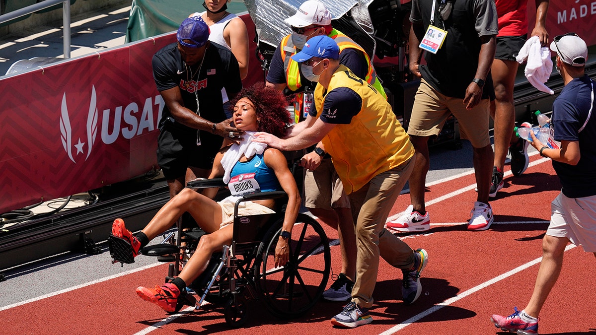 Taliyah Brooks is helped off track after collapsing during the heptathlon at the U.S. Olympic Track and Field Trials Sunday, June 27, 2021, in Eugene, Ore. Events were suspended due to high temperatures. (AP Photo/Charlie Riedel)