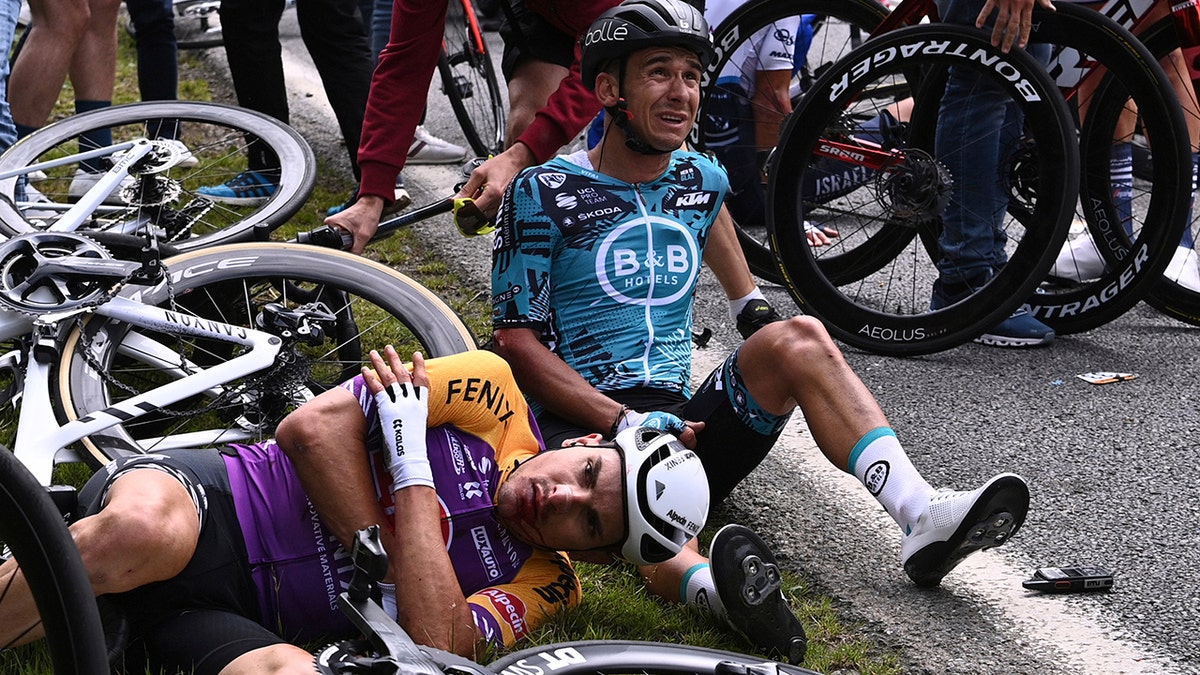 Italy's Kristian Sbaragli, left, and France's Bryan Coquard, right, lie on the ground after crashing during the first stage of the Tour de France. (Anne-Christine Poujoulat, Pool Photo via AP)