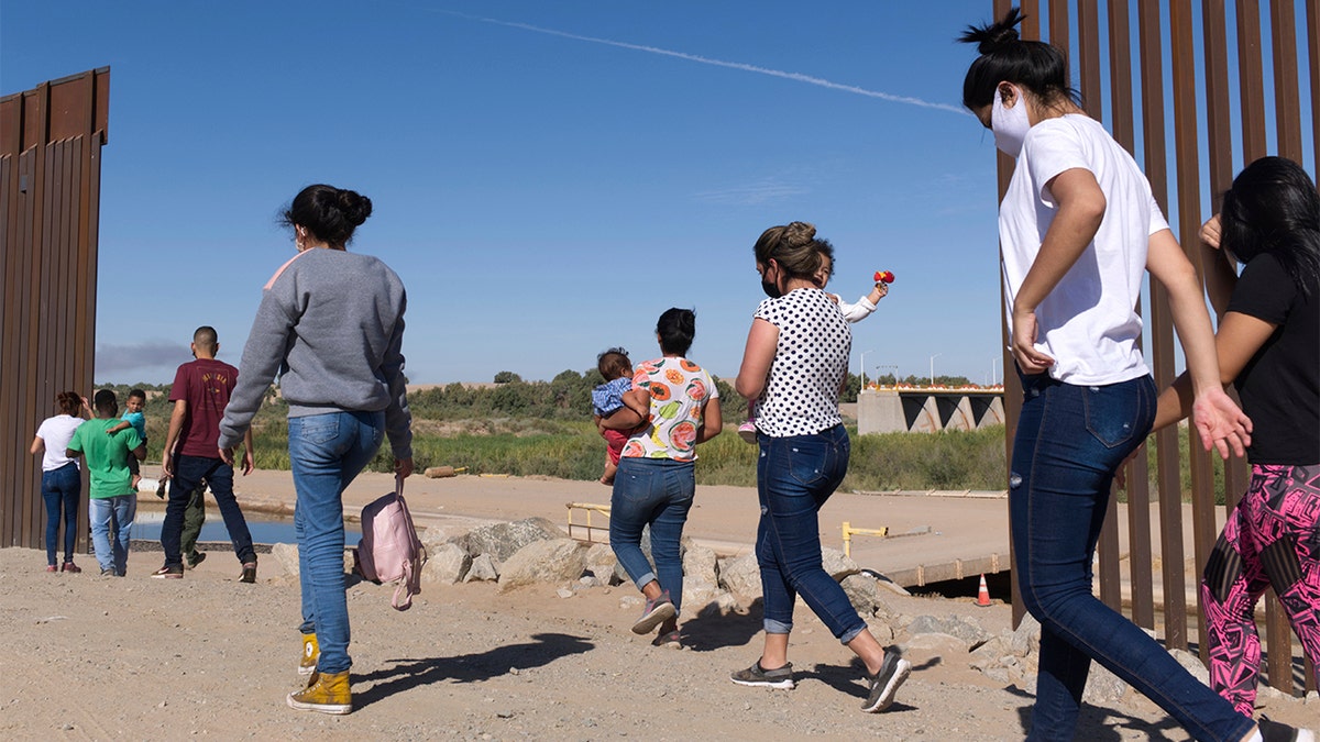 In this Tuesday, June 8, 2021, photo, a group of Brazilian migrants make their way around a gap in the U.S.-Mexico border in Yuma, Ariz., seeking asylum in the United States after crossing over from Mexico. (AP Photo/Eugene Garcia)