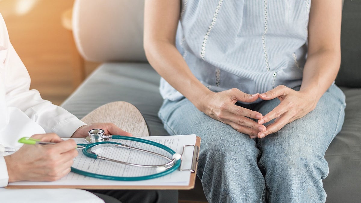 Woman sits in doctor office awaiting answers