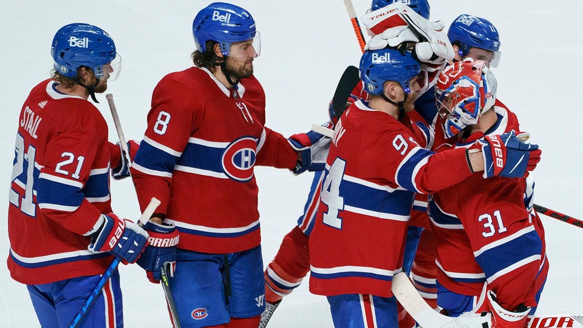 Montreal Canadiens' Eric Staal, Ben Chiarot and Corey Perry, left to right, celebrate their victory with goaltender Carey Price following overtime of Game 6 of an NHL hockey Stanley Cup semifinal playoff series Thursday, June 24, 2021 in Montreal. (Paul Chiasson/The Canadian Press via AP)