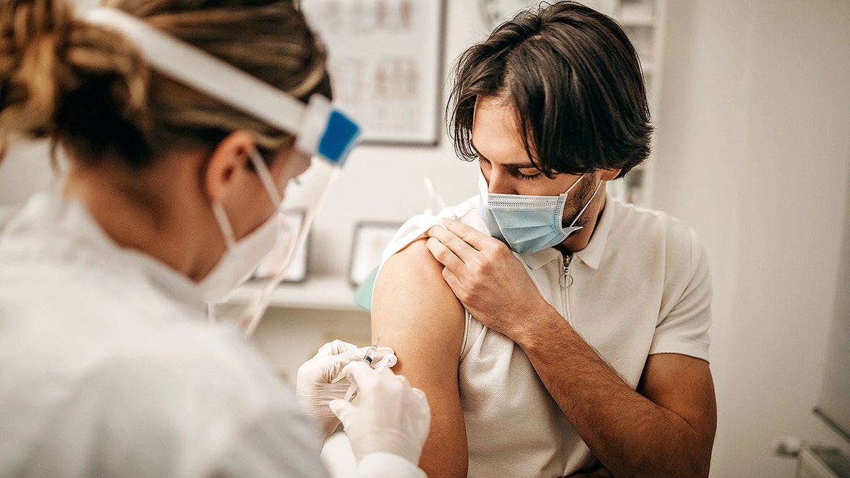 A medical doctor gives an injection for making antibodies to combat the coronavirus.