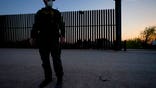 FILE - In this March 21, 2021 file photo, a U.S. Customs and Border Protection agent looks on near a gate on the U.S.-Mexico border wall as agents take migrants into custody, in Abram-Perezville, Texas. Texas Gov. Greg Abbott has has offered scarce details on his plans to construct new barrier along the border with Mexico. It remained unclear Friday, June 11 on how much barrier Texas would erect or where or when it would be installed on the states 1,200-mile border with Mexico.  (AP Photo/Julio Cortez, File)