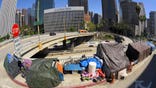 FILE - This May 21, 2020, file photo shows a homeless encampment at the corner of Wilshire Boulevard and Beaudry Avenue along the 110 Freeway during the coronavirus outbreak, in downtown Los Angeles. California lawmakers approved the state's $262.2 billion operating budget Monday, June 28, 2021, that commits $12 billion for homeless programs over the next two years. It now goes to Gov. Gavin Newsom for his signature. (AP Photo/Mark J. Terrill, File)