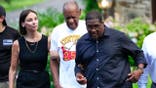 Bill Cosby, center, and spokesperson Andrew Wyatt, right, approach members of the media gathered outside Cosby's home in Elkins Park, Pa., Wednesday, June 30, 2021, after Pennsylvania's highest court overturned his sex assault conviction. (AP Photo/Matt Slocum)