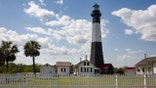 Tybee Island Lighthouse, a historic lighthouse with colonial era ties near Savannah, Georgia.  Classic lighthouse image with fluffy clouds and sunny skies.