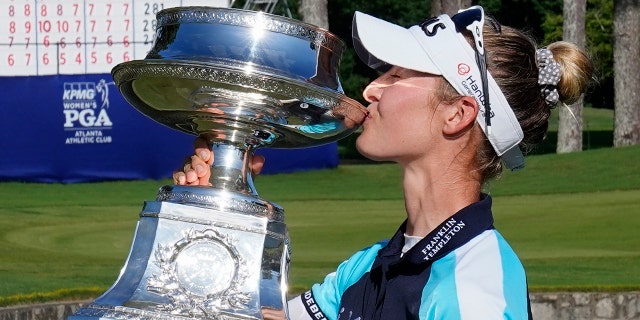 Nelly Korda of the U.S. kisses the trophy after winning the KPMG Women's PGA Championship golf tournament, Sunday, June 27, 2021, in Johns Creek, Ga. (AP Photo/John Bazemore)