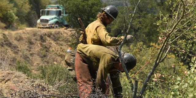 A group of firefighting monks was ready to defend a Buddhist monastery being threatened Tuesday by a wildfire burning in the rugged central coast mountains south of Big Sur.