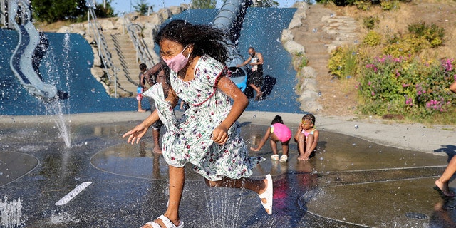 Isis Macadaeg, age 7, plays in a spray park at Jefferson Park during a heat wave in Seattle, Washington, U.S., on June 27, 2021. REUTERS/Karen Ducey