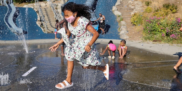Isis Macadaeg, age 7, plays in a spray park at Jefferson Park during a heat wave in Seattle, Washington, U.S., on June 27, 2021. REUTERS/Karen Ducey