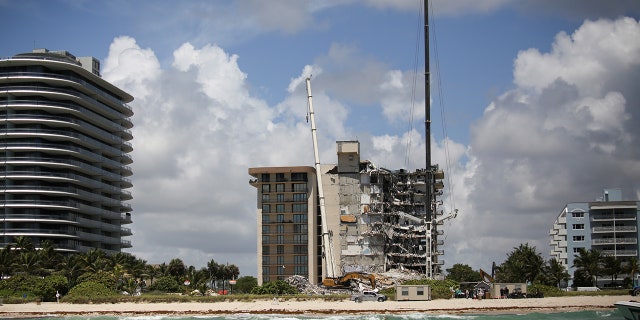 A general view of a partially collapsed residential building as the emergency crews continue search and rescue operations for survivors, in Surfside, near Miami Beach, Florida, U.S. June 27, 2021. REUTERS/Marco Bello