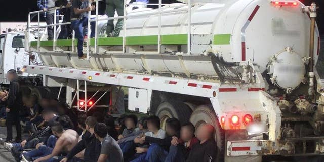 Alleged illegal immigrants are seen outside a gas tanker near Laredo, Texas, on Friday after Border Patrol agents thwarted a human smuggling operation, authorities say. (Customs and Border Protection)