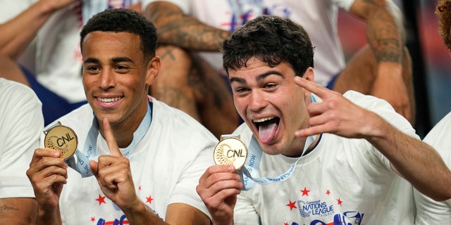 United States' Tyler Adams, left, and Gio Reyna celebrate with their gold medals after an extra time win against Mexico in the CONCACAF Nations League championship soccer match, Sunday, June 6, 2021, in Denver. (AP Photo/Jack Dempsey)