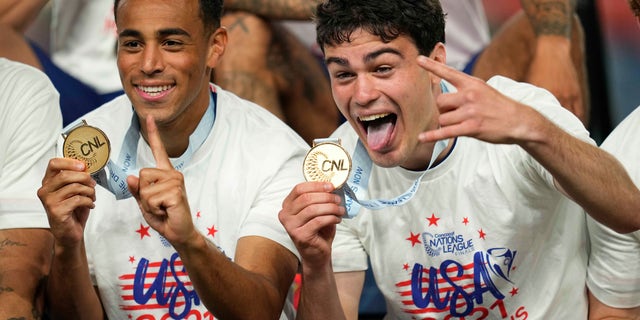 United States' Tyler Adams, left, and Gio Reyna celebrate with their gold medals after an extra time win against Mexico in the CONCACAF Nations League championship soccer match, Sunday, June 6, 2021, in Denver. (AP Photo/Jack Dempsey)