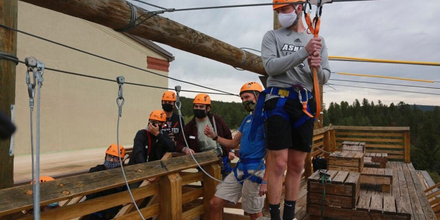 Glorieta Adventure Camp counselor Kole Linville, of Kentucky, trains on a zip line on Friday, May 21, 2021, in Glorieta, New Mexico, before campers arrive. The 3,000-bed camp outside Santa Fe opened up at a third of its normal capacity under pandemic restrictions after being closed last year. (AP Photo/Cedar Attanasio)
