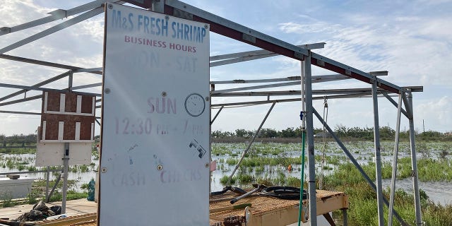 A weathered sign advertises fresh shrimp from a stand owned by Shirley Gray and her husband in Cameron, La. Hurricane Laura last year destroyed one of their boats, heavily damaged another and destroyed much of their equipment. (AP Photo/Rebecca Santana)