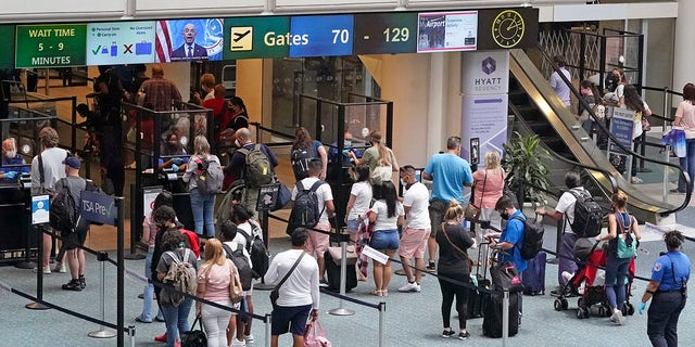 Travelers line up to go through a TSA checkpoint at Orlando International Airport before the Memorial Day weekend Friday, May 28, 2021, in Orlando, Fla. (AP Photo/John Raoux)