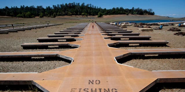 Empty boat docks sit on dry land at the Browns Ravine Cove area of drought-stricken Folsom Lake in Folsom, California, Saturday, May 22, 2021. (Associated Press)