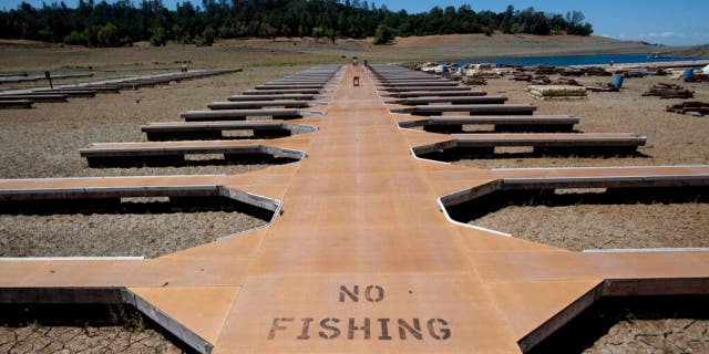 Empty boat docks sit on dry land at the Browns Ravine Cove area of drought-stricken Folsom Lake in Folsom, California, Saturday, May 22, 2021. (Associated Press)