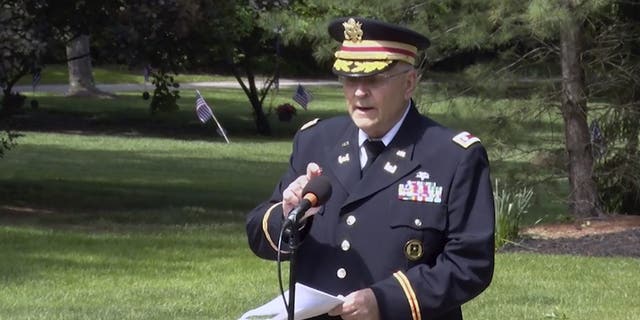 In this frame grab from video provided by Hudson Community Television, retired Army Lt. Col. Barnard Kemter taps the microphone after organizers turned off the audio during his speech at a Memorial Day ceremony, Monday, May 31, 2021, in Hudson, Ohio. Organizers of the ceremony turned off Kemter's microphone when he began talking about how freed Black slaves had honored fallen soldiers soon after the Civil War. (Hudson Community Television via AP)