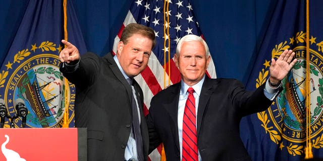 Former Vice President Mike Pence, right, waves as N.H. Gov. Chris Sununu introduces him at the annual Hillsborough County NH GOP Lincoln-Reagan Dinner, Thursday, June 3, 2021, in Manchester, N.H. (AP Photo/Elise Amendola)