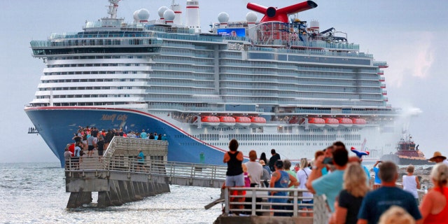 Fans line up at Jetty Park to see the Carnival Cruise Line ship Mardi Gras arrive at Port Canaveral, Florida, early Friday morning. (Joe Burbank/Orlando Sentinel via AP)