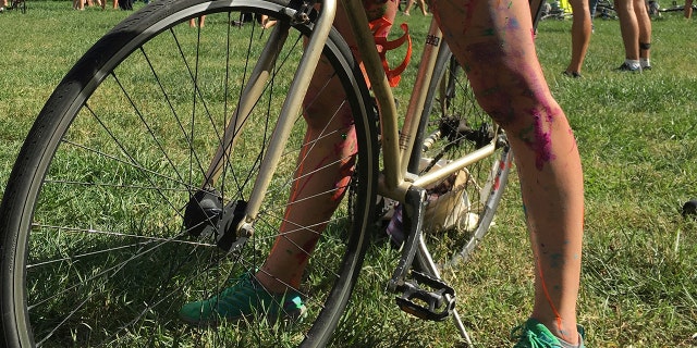 Olivia Neely, a topless cyclist wearing body paint, motions before the start of that year's annual Philly Naked Bike Ride in Philadelphia on Sept. 9, 2017. (AP Photo/Dino Hazell, File)