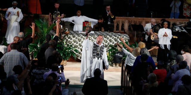 신부님. Michael Pfleger conducts his first Sunday church service as a senior pastor at St. Sabina Catholic Church following his reinstatement by Archdiocese of Chicago after decades-old sexual abuse allegations against minors, 일요일, 유월 6, 2021, in the Auburn Gresham neighborhood in Chicago. (AP Photo/Shafkat Anowar)