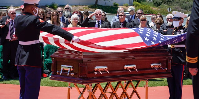 A military honor guard drapes a U.S. flag over the casket of Marine Corps, Pfc. John Franklin Middleswart for a full military honors at Fort Rosecrans National Cemetery, Tuesday, June 8, 2021 in San Diego. Eighty years after he died in the attack on Pearl Harbor and just months after his remains were finally identified, the California Marine has been laid to rest with full military honors. About 50 people attended the ceremony Tuesday for Middleswart in his hometown of San Diego, the Union-Tribune reported. (Nelvin C. Cepeda/The San Diego Union-Tribune via AP)