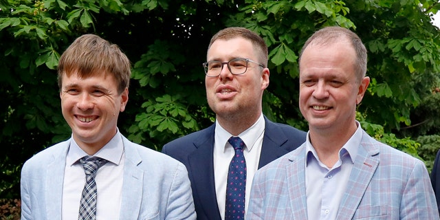 Russian lawyers Ivan Pavlov, right, Vladimir Voronin, center, and Yevgeny Smirnov smile during a break in a court session in front of Moscow Court in Moscow, Russia, Wednesday, June 9, 2021. A Moscow court has outlawed the organizations founded by Russian opposition leader Alexei Navalny by labeling them extremist, the latest move in a campaign to silence dissent and bar Kremlin critics from running for parliament in September. The Moscow City Court's ruling, effective immediately, prevents people associated with Navalny's Foundation for Fighting Corruption and his sprawling regional network from seeking public office. (AP Photo/Alexander Zemlianichenko)