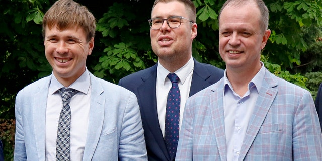 Russian lawyers Ivan Pavlov, right, Vladimir Voronin, center, and Yevgeny Smirnov smile during a break during a court hearing in Moscow, Russia on Wednesday, June 9, 2021. A Moscow court has banned organizations founded by Russian opposition leader Alexei Navalny as extremists, the latest move in a campaign to silence dissent and ban Kremlin critics from running for parliamentary elections in September. The Moscow City Court's ruling, which takes effect immediately, prevents those associated with the Navalny Anti-Corruption Foundation and its sprawling regional network from running for public office. (AP Photo / Alexander Zemlianichenko)