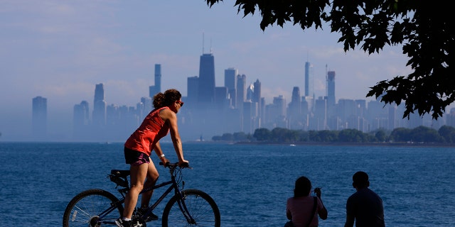 People spend time as they take advantage of warm summer weather along Lake Michigan, Wednesday, June 9, 2021 in Montrose Beach in Chicago. The beaches in Chicago have reopened since closing over a year ago because of the coronavirus pandemic. (AP Photo/Shafkat Anowar)