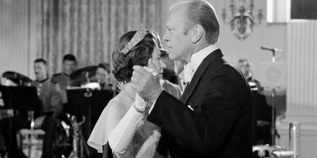 Sur cette photo d'archive datée du 7 juillet 1976, le président américain Gerald Ford danse avec la reine Elizabeth II de Grande-Bretagne dans la salle à manger d'État de la Maison Blanche après un dîner d'État en l'honneur de la reine. (AP Photo/John Duricka, dossier)