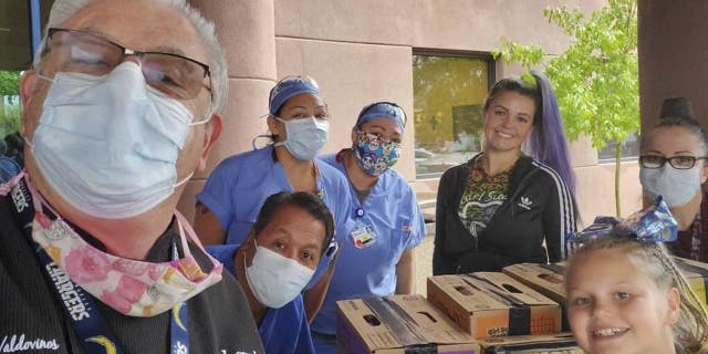Henrique Valdovinos (left), and other health care workers at the Lovelace Women's Hospital in Albuquerque, New Mexico, received a cookie donation from the Girl Scouts of New Mexico Trails. The donation was a part of the troop's Hometown Heroes program. (Girl Scouts of New Mexico Trails via AP)