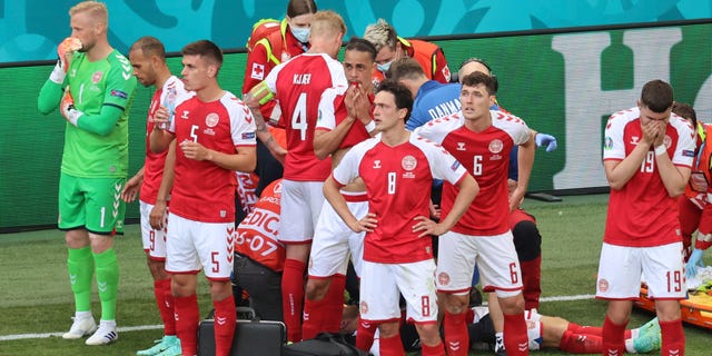 Denmark's players react as their teammate Christian Eriksen lays on the ground during the Euro 2020 soccer championship group B match between Denmark and Finland at Parken stadium in Copenhagen, Denmark, Saturday, June 12, 2021. (Wolfgang Rattay/Pool via AP)