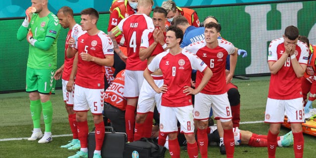 Denmark's players react as their teammate Christian Eriksen lays on the ground during the Euro 2020 soccer championship group B match between Denmark and Finland at Parken stadium in Copenhagen, Denmark, Saturday, June 12, 2021. (Wolfgang Rattay/Pool via AP)