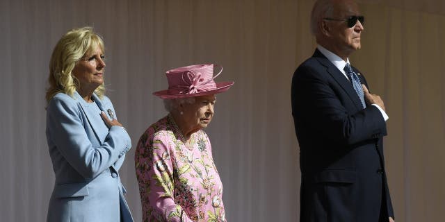 Britain's Queen Elizabeth II stands with US President Joe Biden and First Lady Jill Biden as they listen to the US national anthem at Windsor Castle near London, Sunday, June 13, 2021. (AP Photo/Alberto Pezzali)