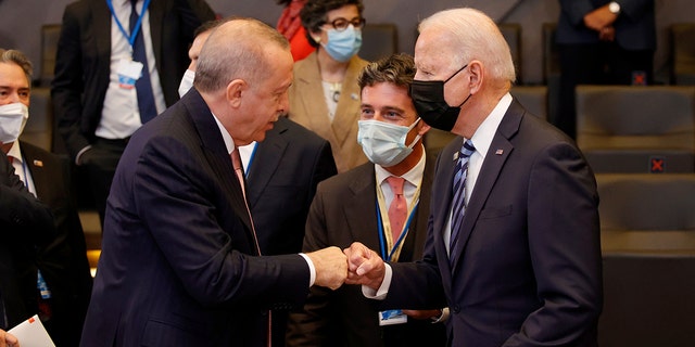 U.S. President Joe Biden, right, is greeted by Turkey's President Recep Tayyip Erdogan, center, during a plenary session at a NATO summit in Brussels, Monday, June 14, 2021. (AP Photo/Olivier Matthys, Pool)