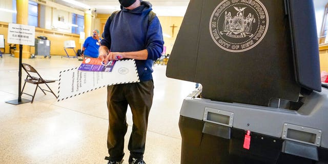 Rafael Risember, 62, prepares to scan his ballot as he participates in early voting in the primary election, Monday, June 14, 2021, at the Church of St. Anthony of Padua in the Soho neighborhood of New York. (AP Photo/Mary Altaffer)