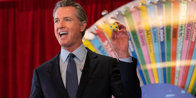 FILE - In this June 4, 2021, file photo, California Gov. Gavin Newsom holds up a lottery ball at the California Lottery Headquarters on Friday, June 4, 2021, in Sacramento, Calif., while drawing numbers for California's new vaccine incentive program. (Paul Kitagaki Jr./The Sacramento Bee via AP, File)/The Sacramento Bee via AP)