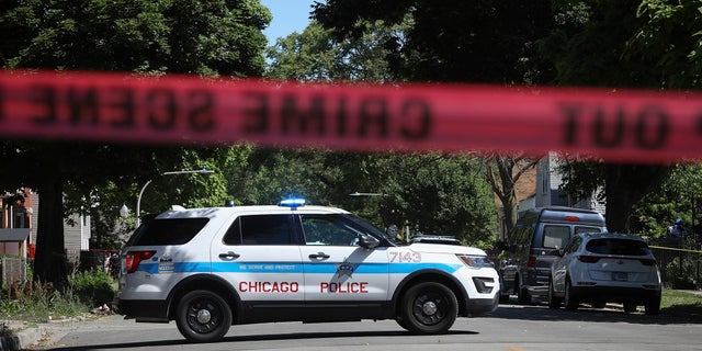 Police tape marks off a Chicago street as officers investigate the scene of a fatal shooting in the city's South Side on Tuesday. An argument in a house erupted into gunfire early Tuesday, police said. (AP Photo/Teresa Crawford)