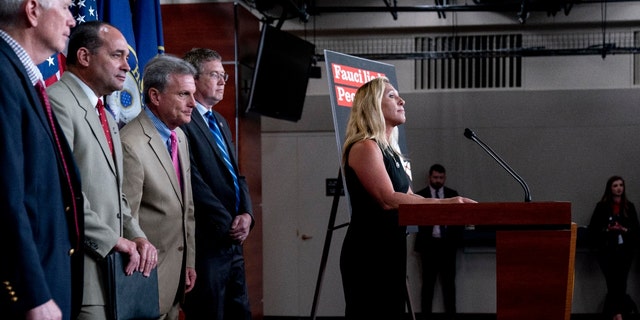 Rep. Marjorie Taylor Greene, R-Ga., right, accompanied by from left, Rep. Mo Brooks, R-Ala., Rep. Bob Good, R-Va., Rep. Buddy Carter, R-Ga., and Rep. Thomas Massie, R-Ky., takes a question during a news conference. (AP Photo/Andrew Harnik)